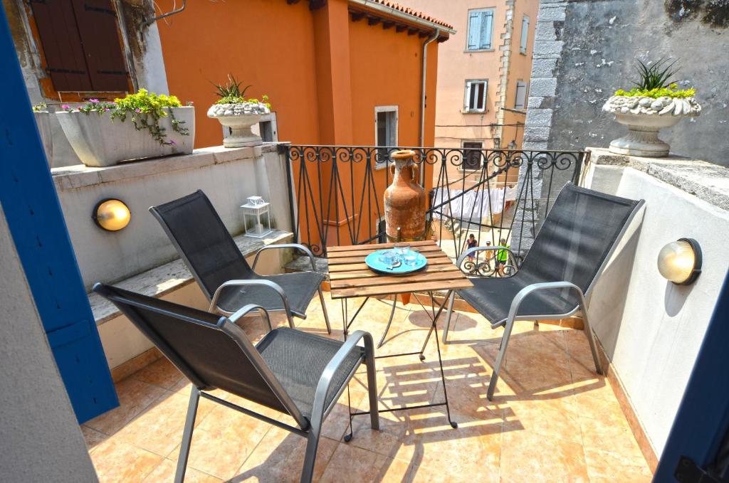 Un patio con sillas y una mesa en el balcón. en Lighthouse Montalbano en Rovinj