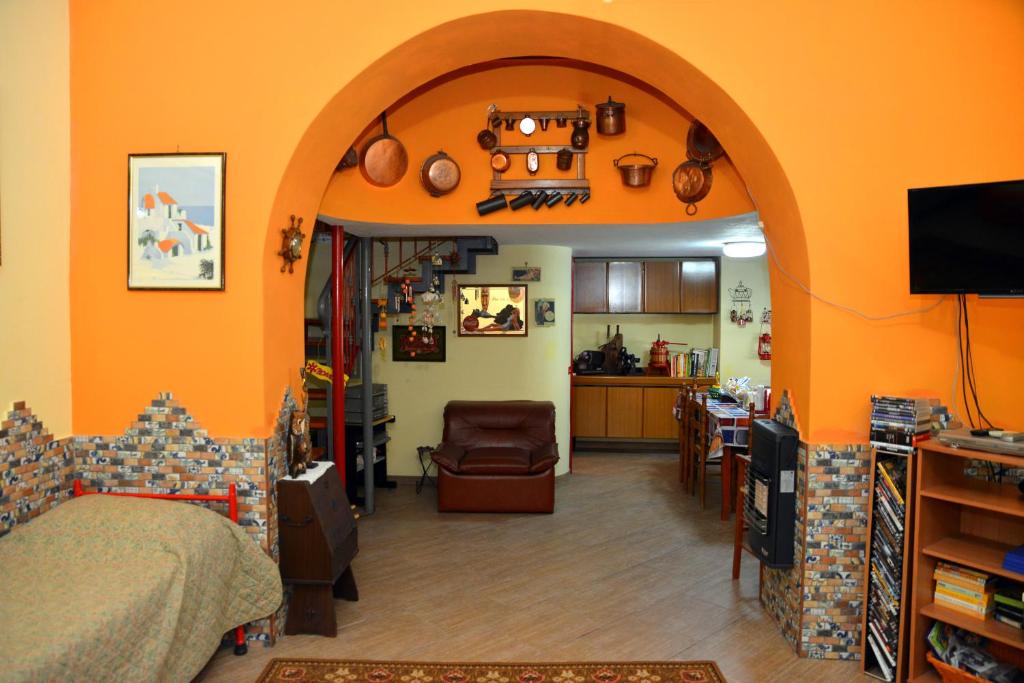 orangefarbenes Zimmer mit einem Bett und einer Küche in der Unterkunft The Alley Inn in Santa Maria Capua Vetere