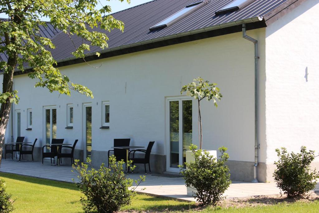 a white building with black chairs and tables at 272 Bed & Breakfast in Esbjerg