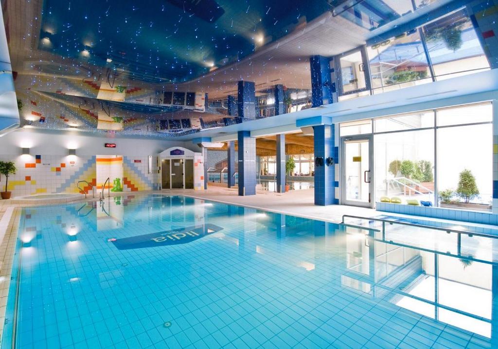 ein großer Pool in einem großen Gebäude in der Unterkunft Hotel Lidia Spa & Wellness in Darłówko