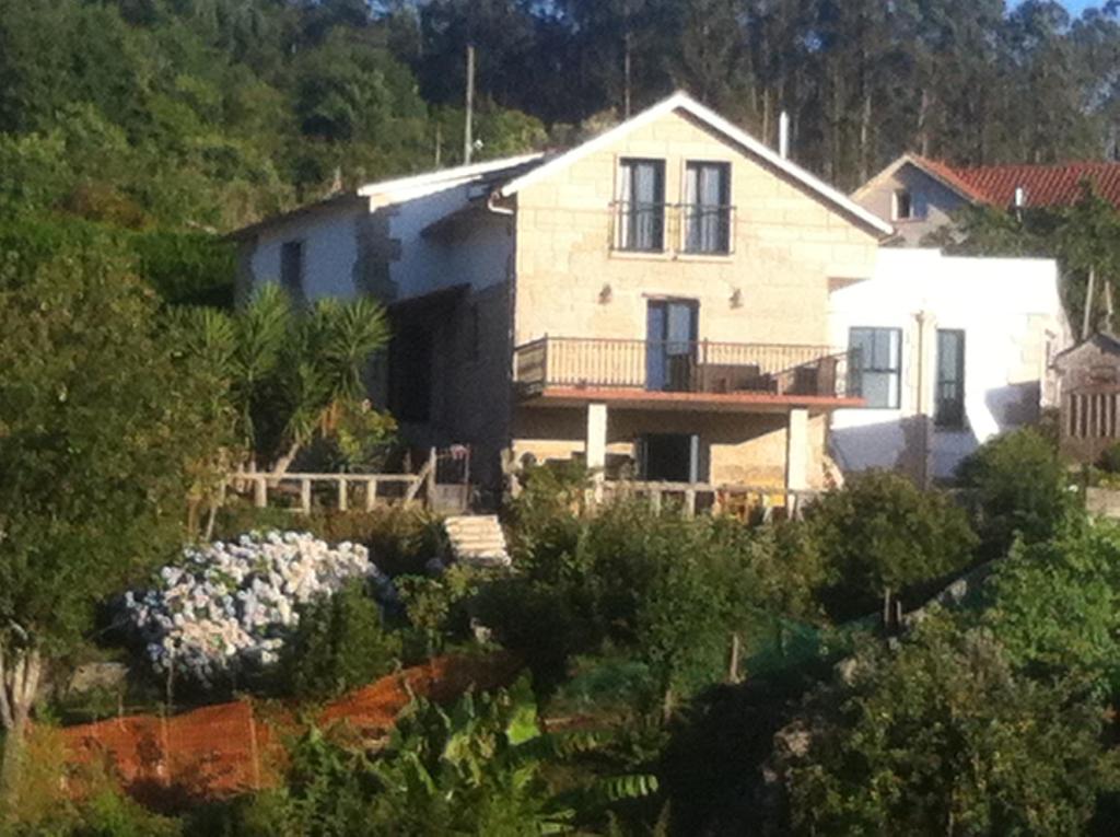 uma casa numa colina com um jardim em Hostal Casa Martinez em Bueu