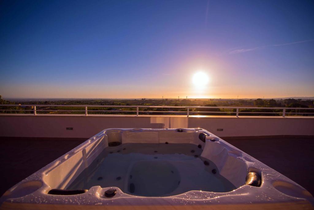 a bath tub on the roof of a building with the sunset at La Terrazza di Harmakhis in Partanna