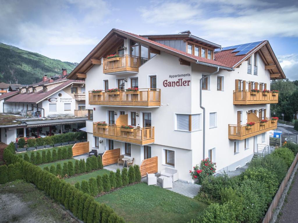 um grande edifício branco com varandas de madeira em Appartement Gandler em Valdaora