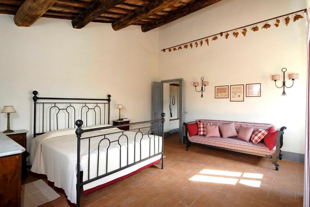 a bedroom with a bed and a couch at Agriturismo Pian Del Tevere in Torgiano