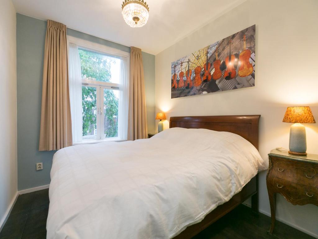 1 dormitorio con cama blanca y ventana en The Sunny Suite - R.Q.C., en La Haya