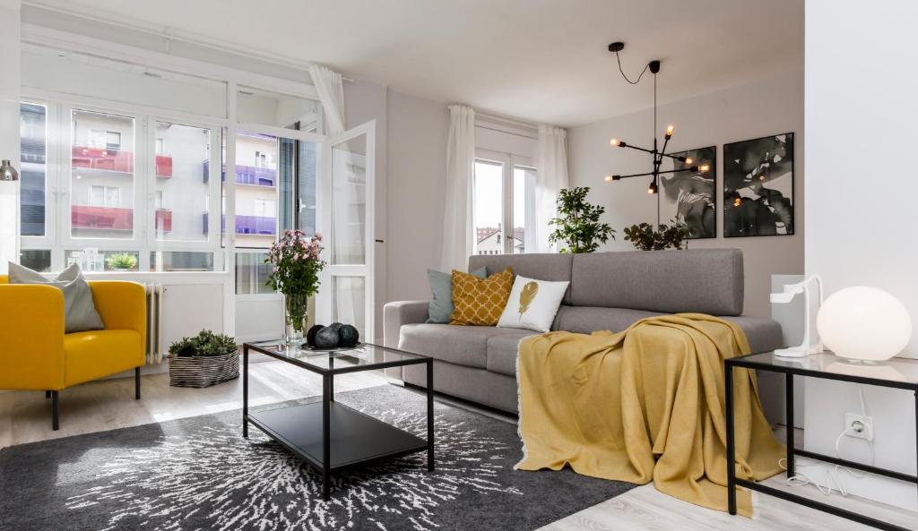 a living room with a couch and a yellow chair at Trave - Bayona in Pamplona