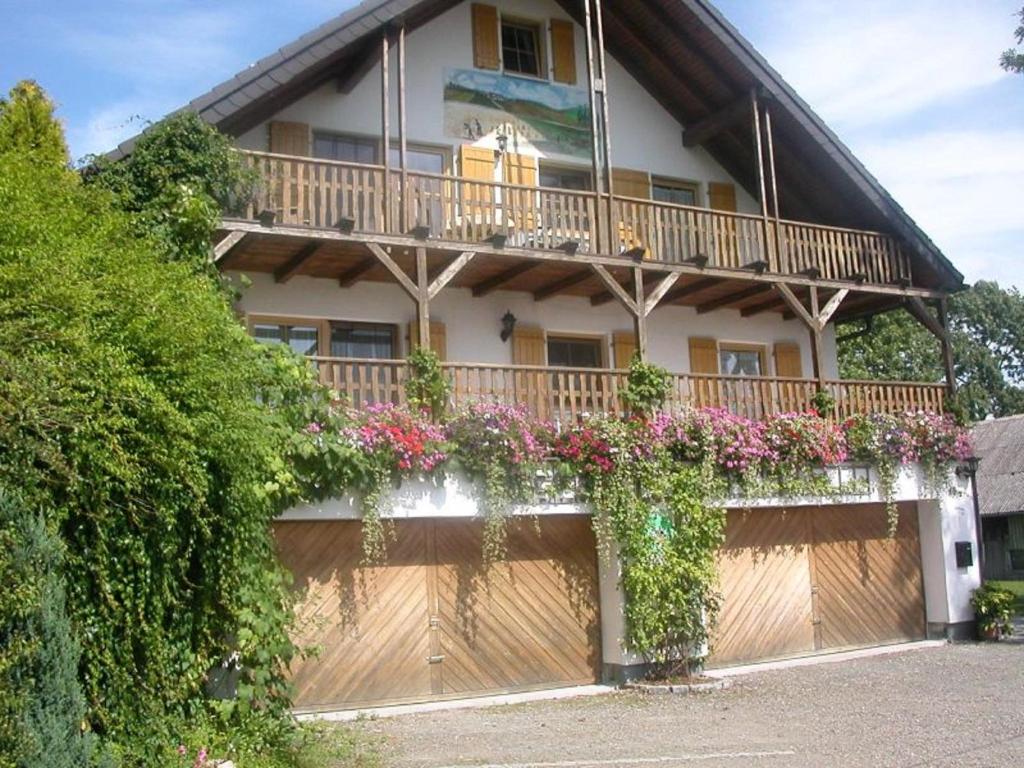 una casa con un balcón con flores. en Gästehaus Fichtelgebirgsblick, en Stammbach