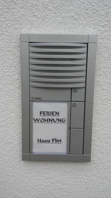 uma caixa de metal com um sinal que diz que o trabalho de Sayfren tem flerte em Haus Fliri em Curon Venosta