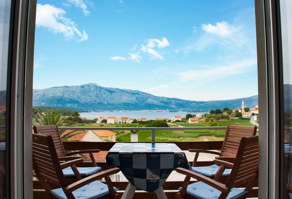 a table and chairs on a balcony with a view of a lake at House Baglija in Lumbarda