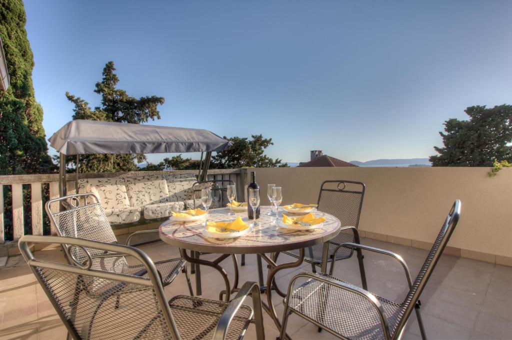 a patio table with chairs and a bottle of wine at Apartment near sandy Firule Beach in Split