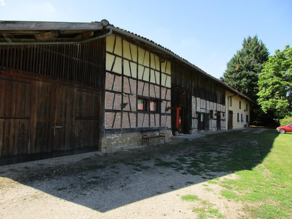 um grande edifício com uma cerca ao lado de um campo em La Closerie em Saint-Nizier-le-Bouchoux