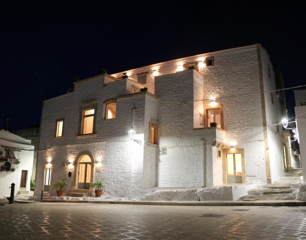 a large white brick building with lights on it at Palazzo Camarda B&B in Ceglie Messapica