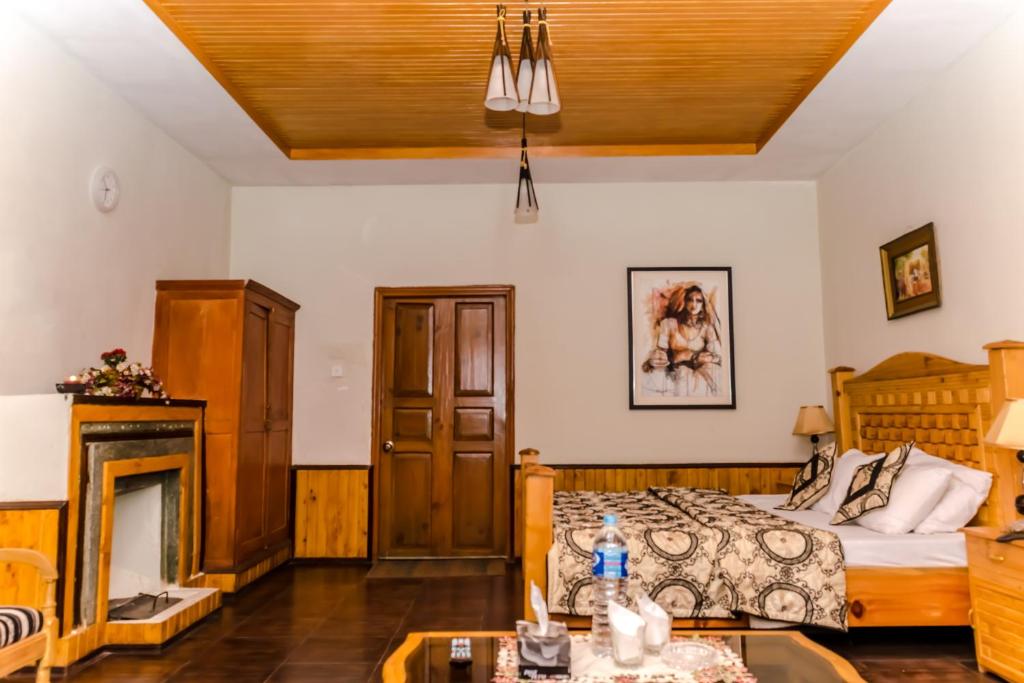 a bedroom with a bed and a fireplace at Pine Top Hotel Murree in Murree