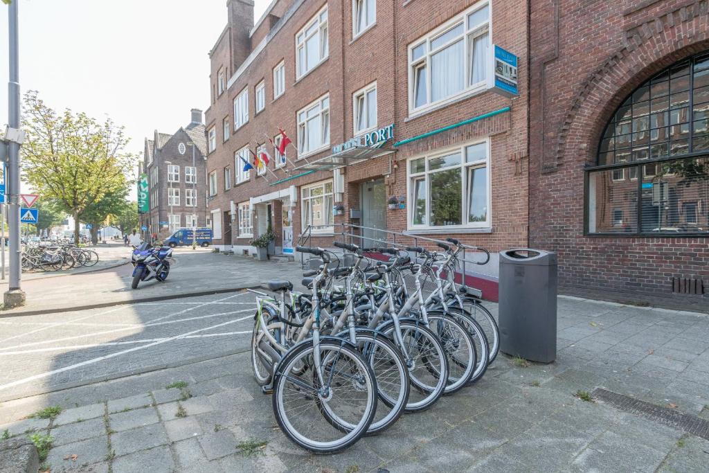 Un tas de vélos garés devant un bâtiment dans l'établissement Hotel Port, à Rotterdam