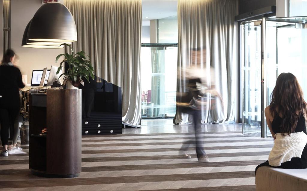 Eine Frau auf einer Couch im Wohnzimmer in der Unterkunft c-hotels Ambasciatori in Florenz