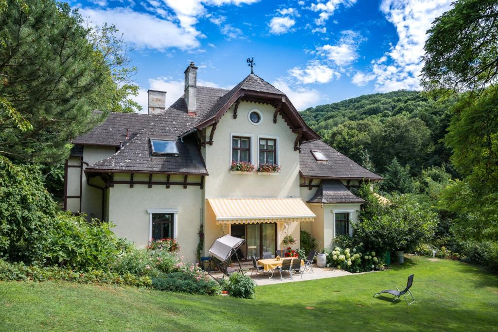 une grande maison blanche avec un toit dans l'établissement Villa Neuwirth, à Greifenstein
