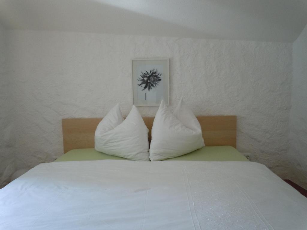 Una cama blanca con dos almohadas encima. en Appartementhaus Dargham en Strobl