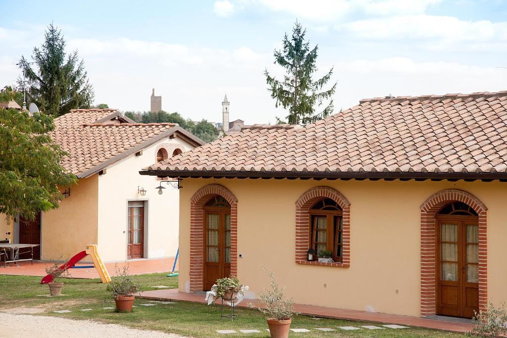 une petite maison avec un toit carrelé dans une cour dans l'établissement Agriturismo Il Piastrino, à Vinci
