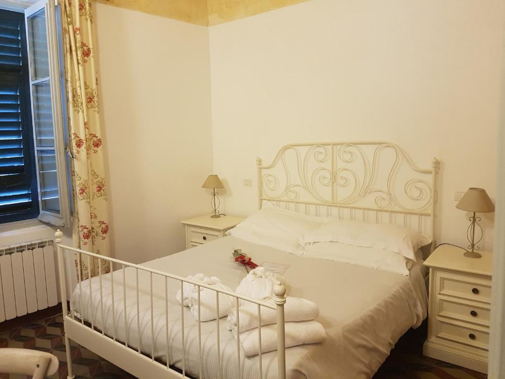 1 dormitorio con cama blanca y almohadas blancas en Ca di Ni en Finale Ligure
