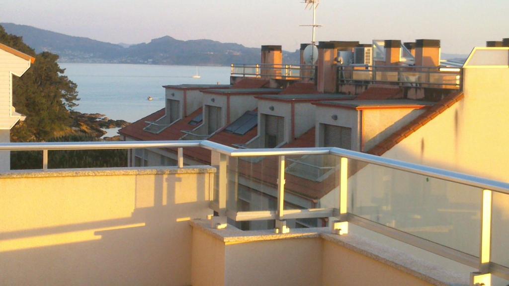 a balcony of a building with a view of the water at Apartamentos Rúa Virxe do Carme in Sanxenxo