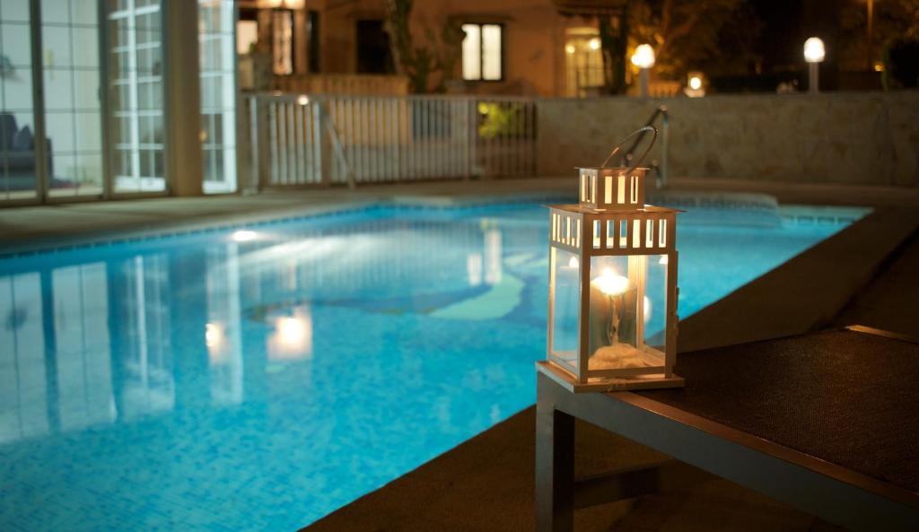 uma lanterna sentada ao lado de uma piscina à noite em Villa Els Pins em Palma de Maiorca