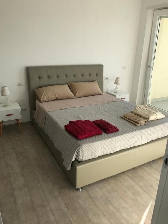 フランカヴィッラ・アル・マーレにあるAppartamento Stella del Mare Topのベッドルーム1室(赤い枕2つ付)