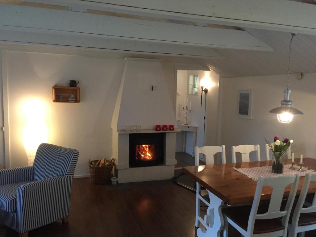 a living room with a table and a fireplace at Stuga i Ullared in Ullared