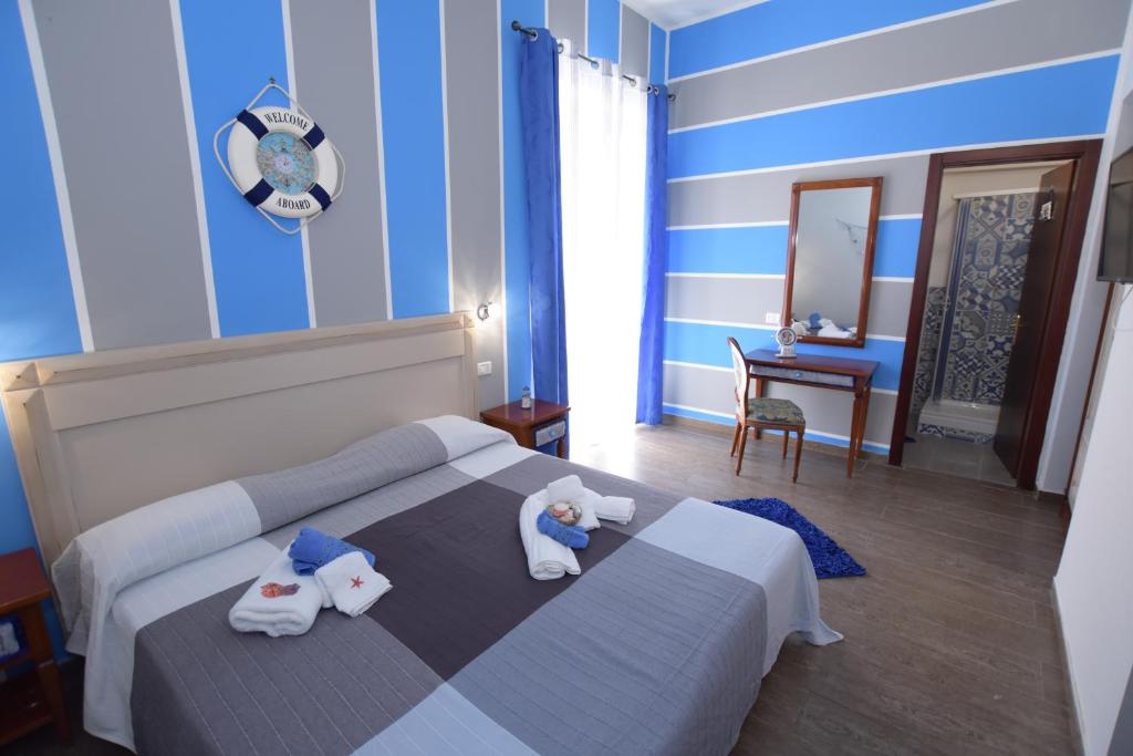 una camera da letto con un letto e asciugamani di B&B Empedocle a Porto Empedocle