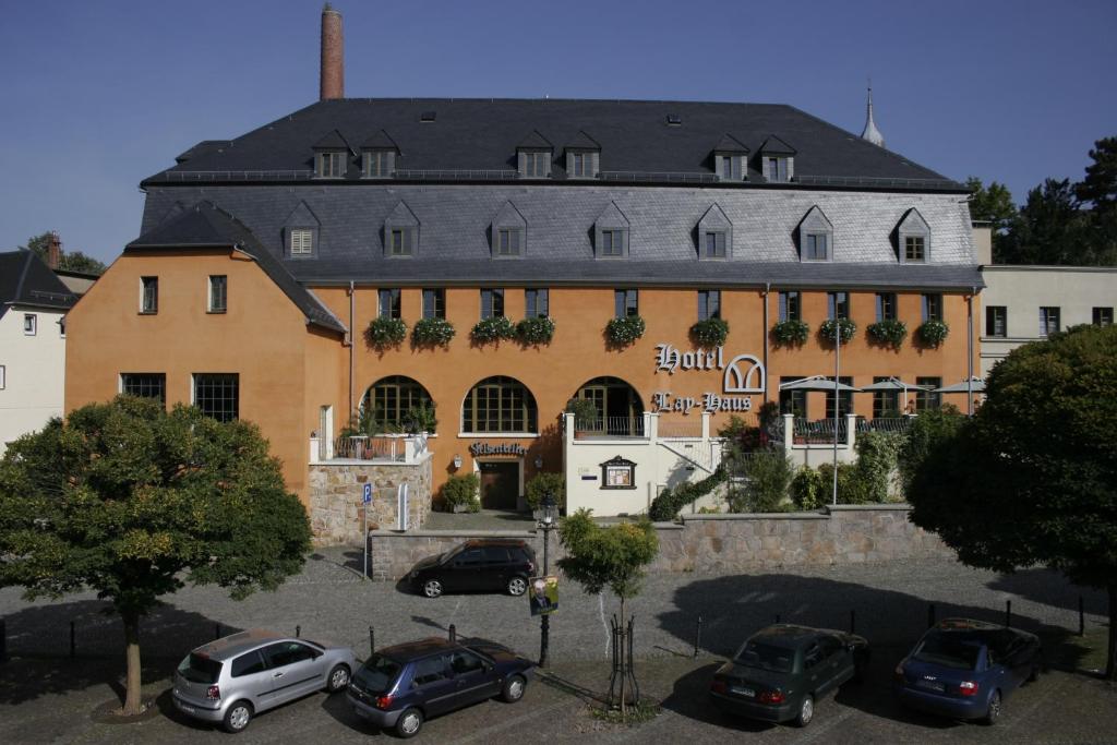 a large building with cars parked in a parking lot at Hotel Lay-Haus in Limbach-Oberfrohna