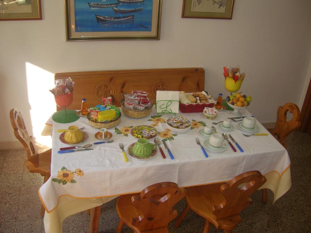 a table with a white table cloth with food on it at Casa vacanze Ex B&B La Bicocca - Via Umberto 15 in Sorso