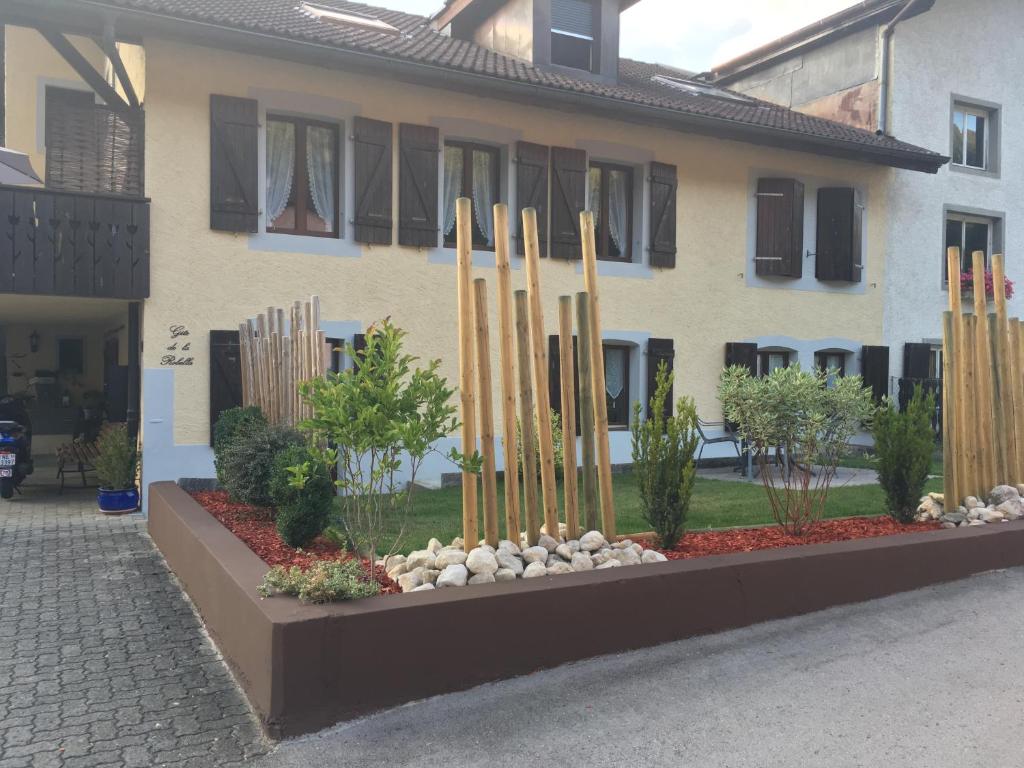 un edificio con un jardín con palos de madera en Gite de la Robella en Buttes