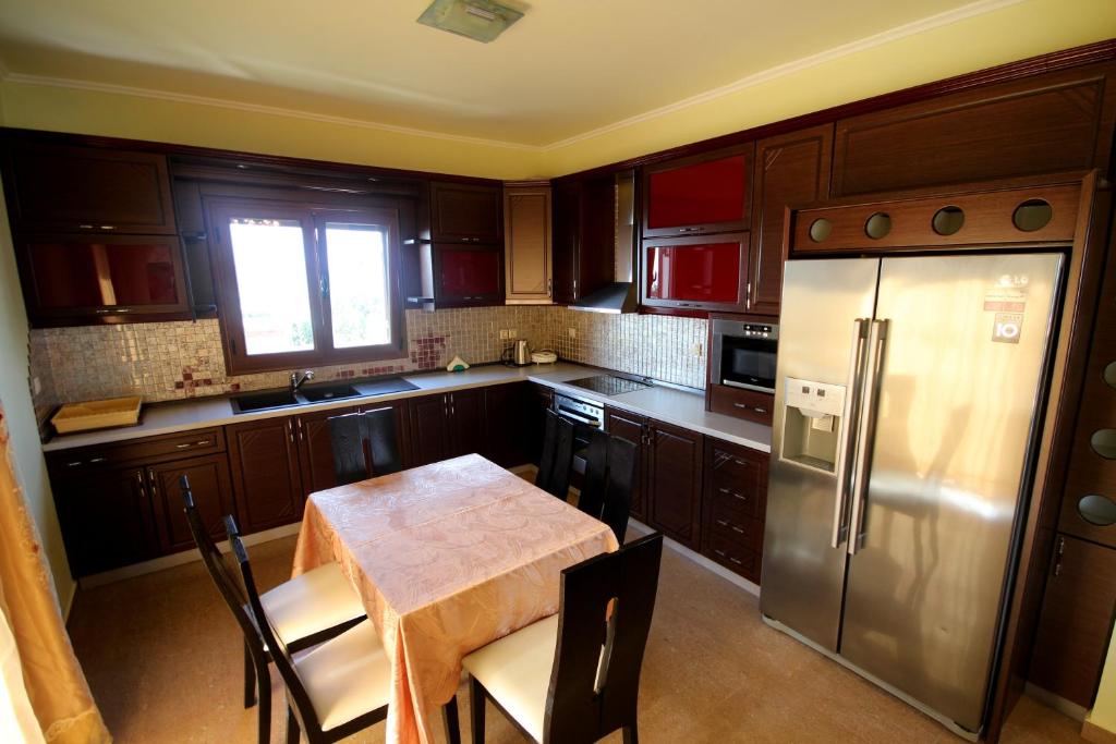 a kitchen with a table and a stainless steel refrigerator at Mihal Suites in Sarandë