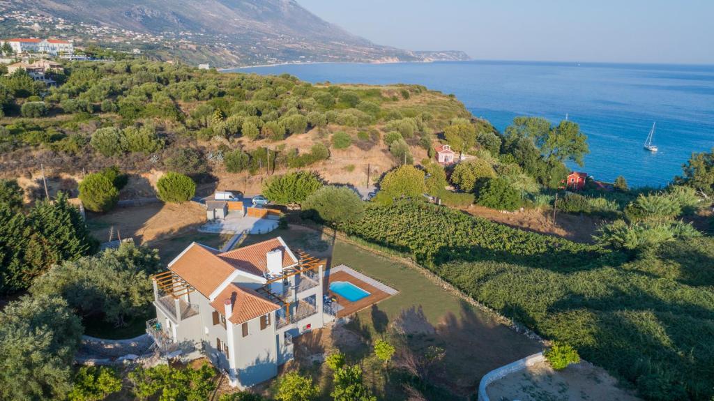 an aerial view of a house on a hill next to the ocean at Filon Ktima Beachfront Upscale Villa in Karavadhos