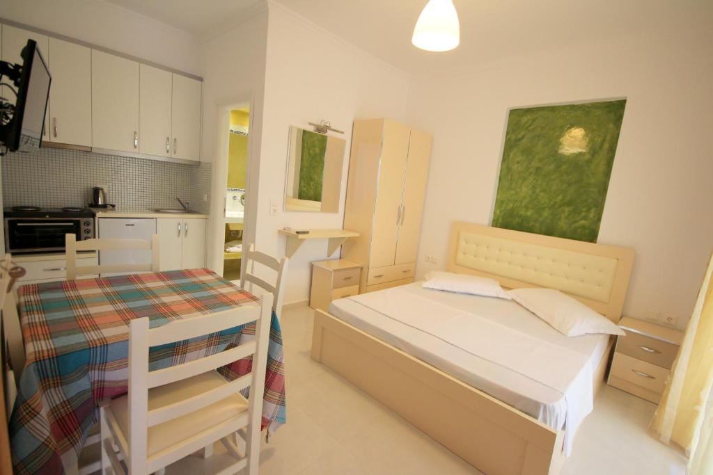 a small bedroom with a bed and a kitchen at Mihal Suites in Sarandë