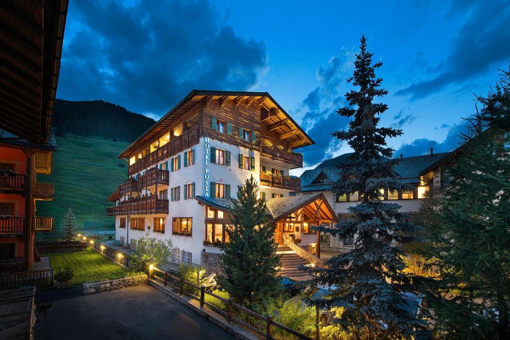 un grande edificio con un albero di Natale davanti di Hotel Posta a Livigno