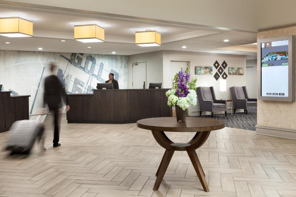 a lobby with a woman walking past a reception desk at DoubleTree by Hilton Minneapolis Park Place in Saint Louis Park