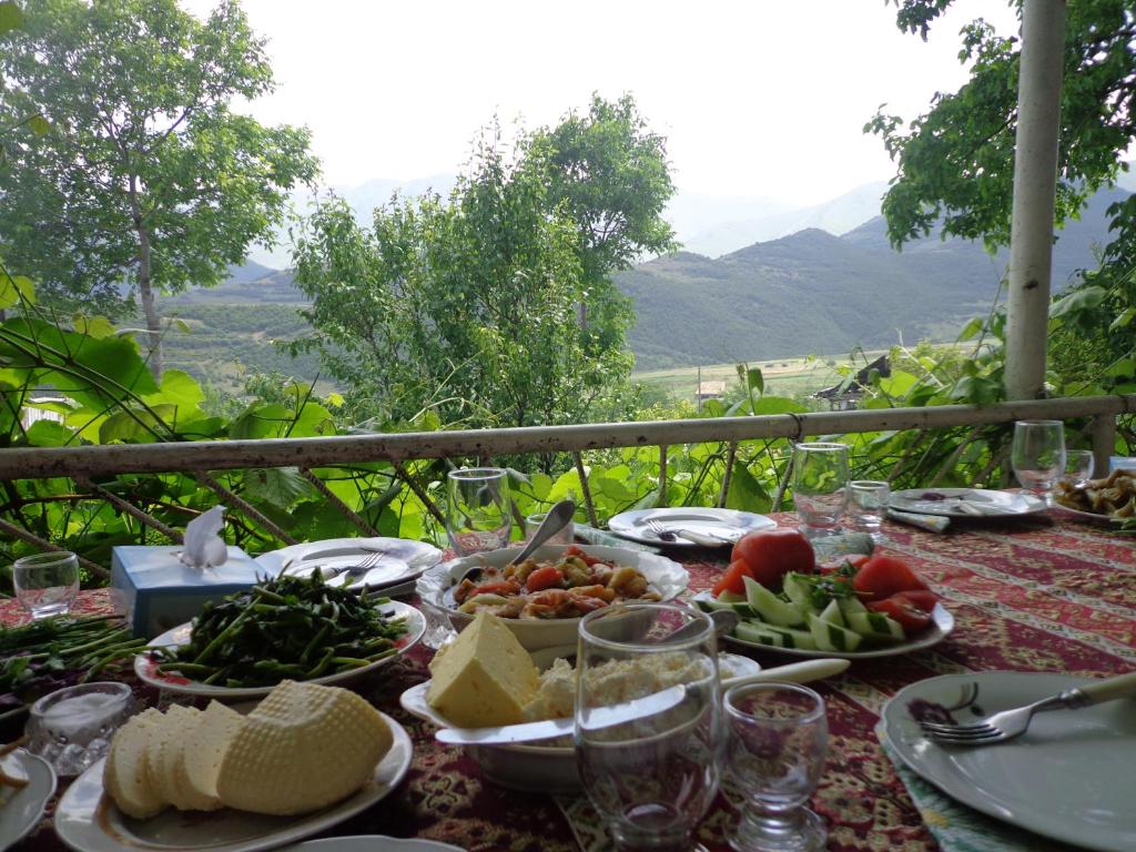 a table with plates of food on it with a view at Anush`s B&B in Tatʼev