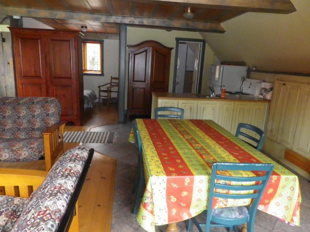 een kamer met een tafel en stoelen en een keuken bij Auberge La Seigneurie Valcartier in Saint-Gabriel-De-Valcartier