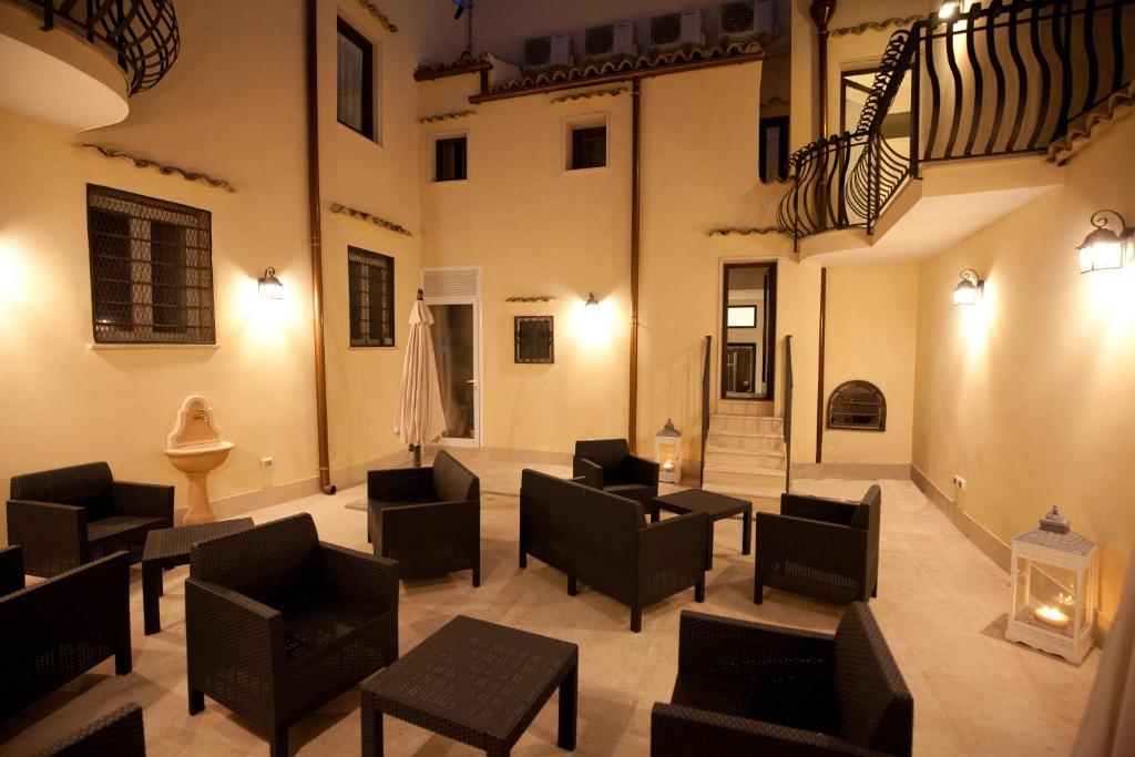 a living room with chairs and tables in a building at Italiana Resort Maniace in Siracusa