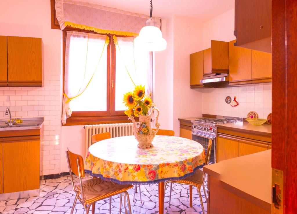 a kitchen with a table with a vase of flowers on it at Balcon des Alpes in Teglio