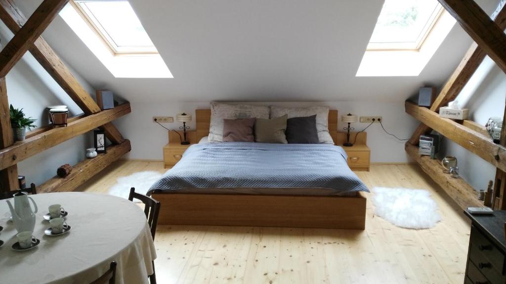 een slaapkamer met een bed op een zolder met dakramen bij Stylové podkrovní apartmány Ostrava in Ostrava