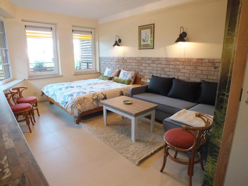 uma sala de estar com uma cama e um sofá em Apartments Ąžuolas em Palanga