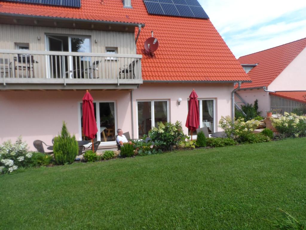 een huis met rode paraplu's in een tuin bij Pension am Kirschgarten in Gößweinstein