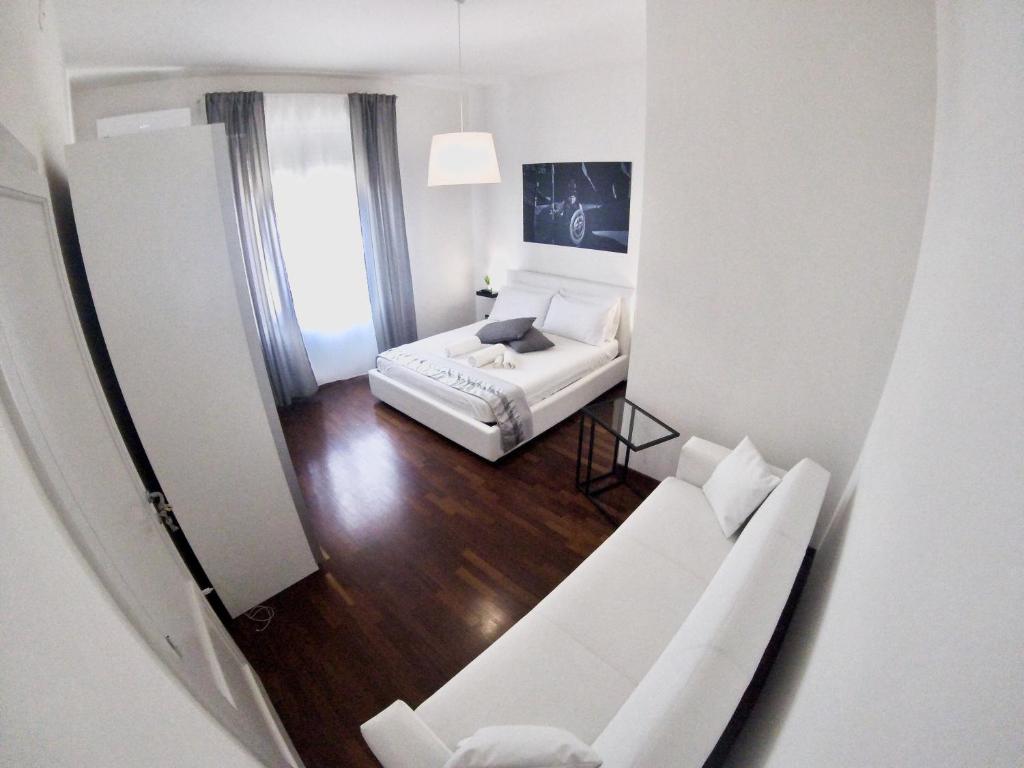 uma sala de estar branca com um sofá e uma mesa em Mythos Affittacamere em Siracusa