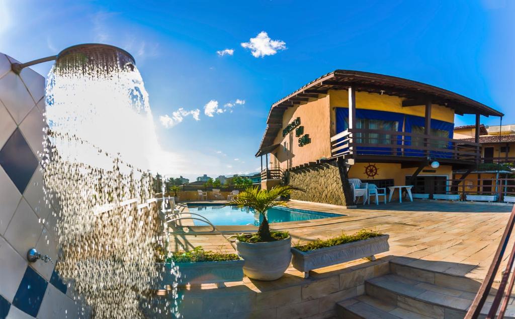 einen Brunnen vor einem Haus in der Unterkunft Hotel Pousada do Sol in Ubatuba