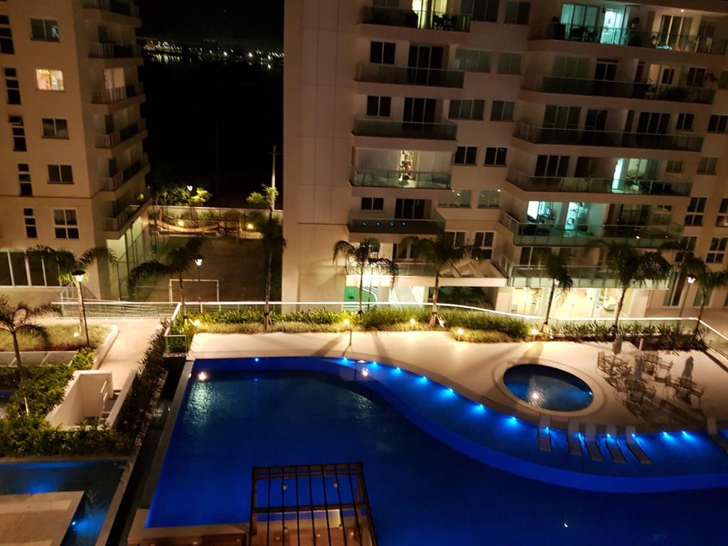uma piscina no meio de um edifício à noite em Apartamento Barra Paraíso Tropical no Rio de Janeiro