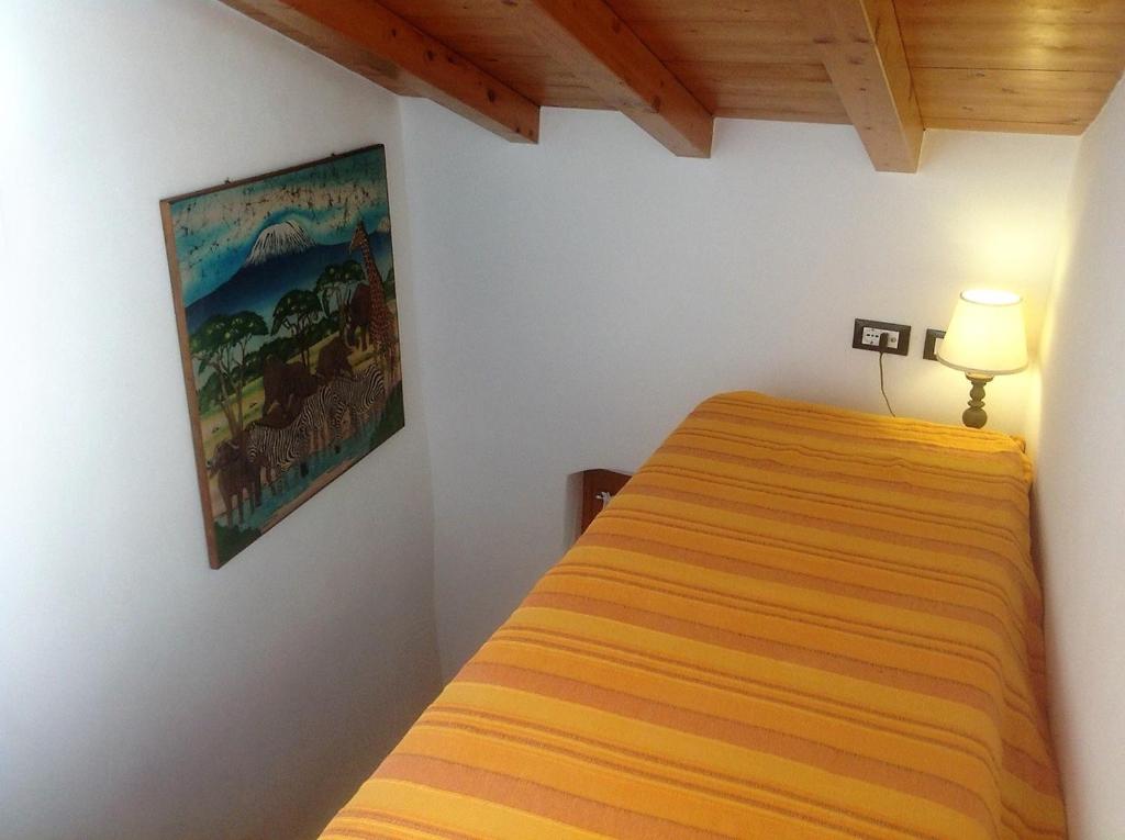a bedroom with a bed and a painting on the wall at Casa Vacanze Storica in Seborga