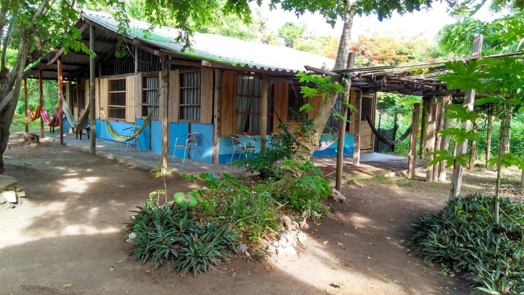 una pequeña casa de madera con techo azul en Ecohotel Arte y Aventura, en Isla Grande