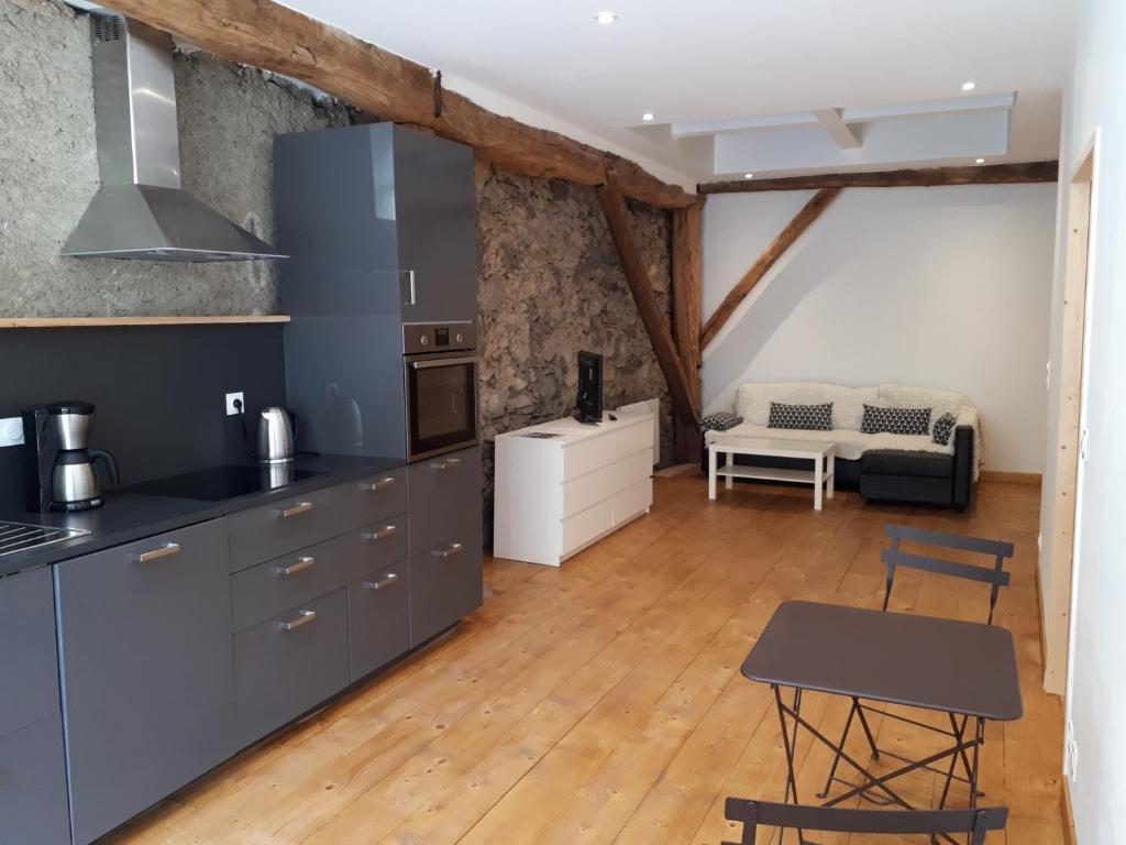 Domaine de la Safranière - Holiday Home في Saint-Léger: مطبخ وغرفة معيشة مع طاولة وكراسي