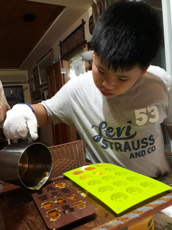 a young boy standing at a table looking in a mirror at Light and Shadow B&amp;B in Yuanshan